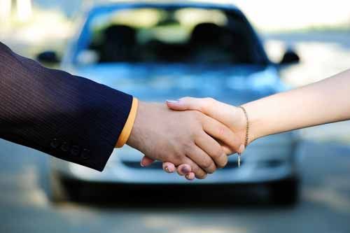 An Oklahoma Motor Vehicle Dealer shakes hands with a customer